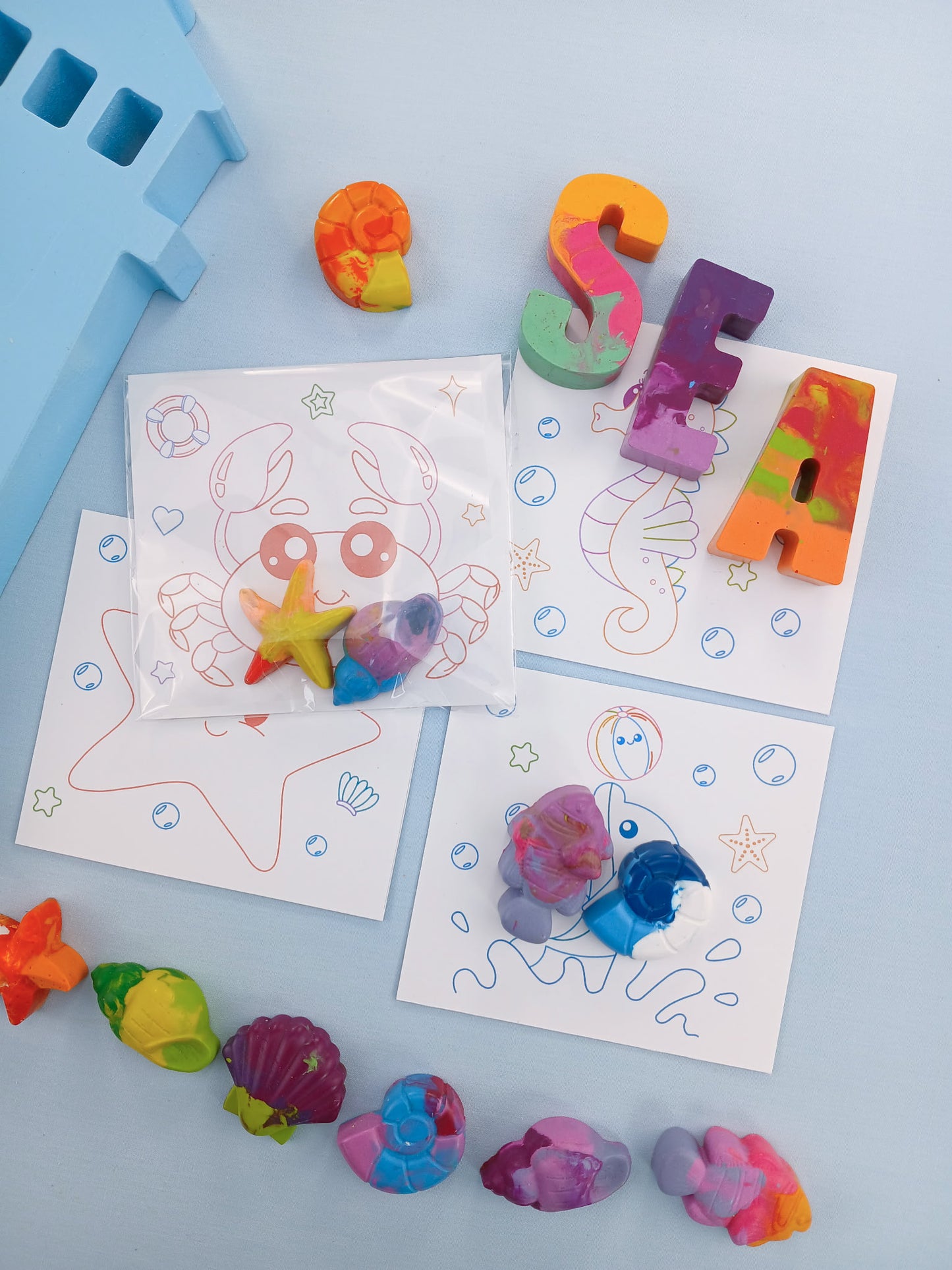 Under the Sea favor bags with 2–3 crayons and coloring cards featuring starfish and seashells, non-candy kids favors