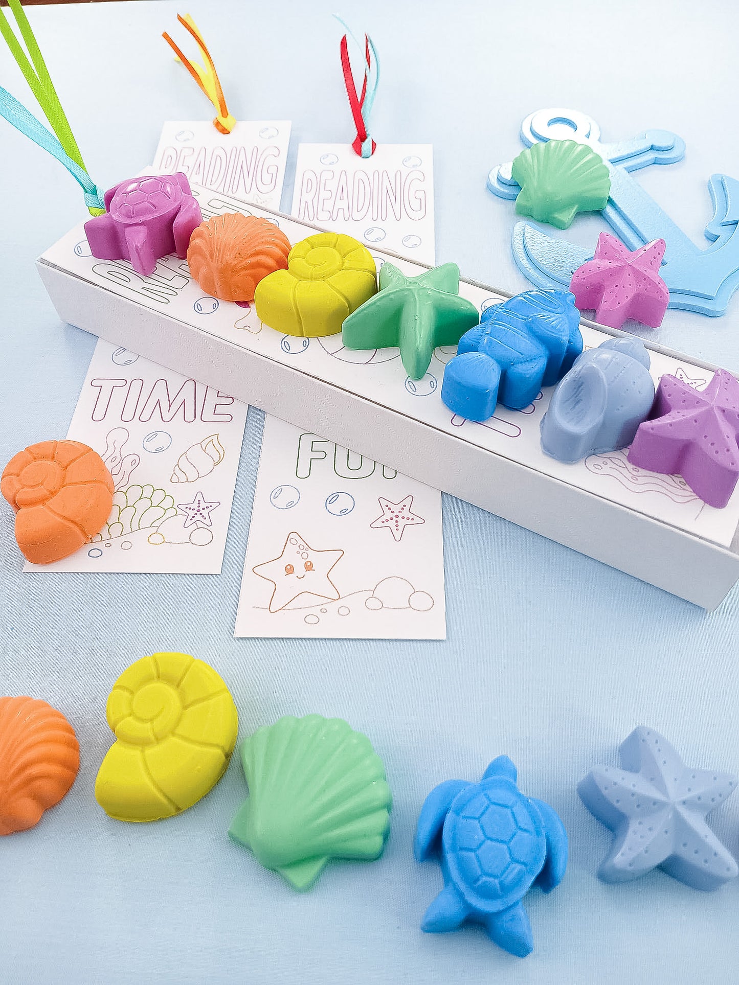 Box of pastel sea creature crayons with rainbow colors and coloring bookmark, handmade non-toxic art gift.