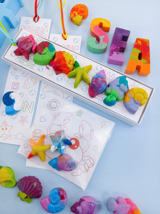 Under the Sea crayon party favors with pastel sea creature crayons, coloring bookmarks, and ocean-themed gift box.